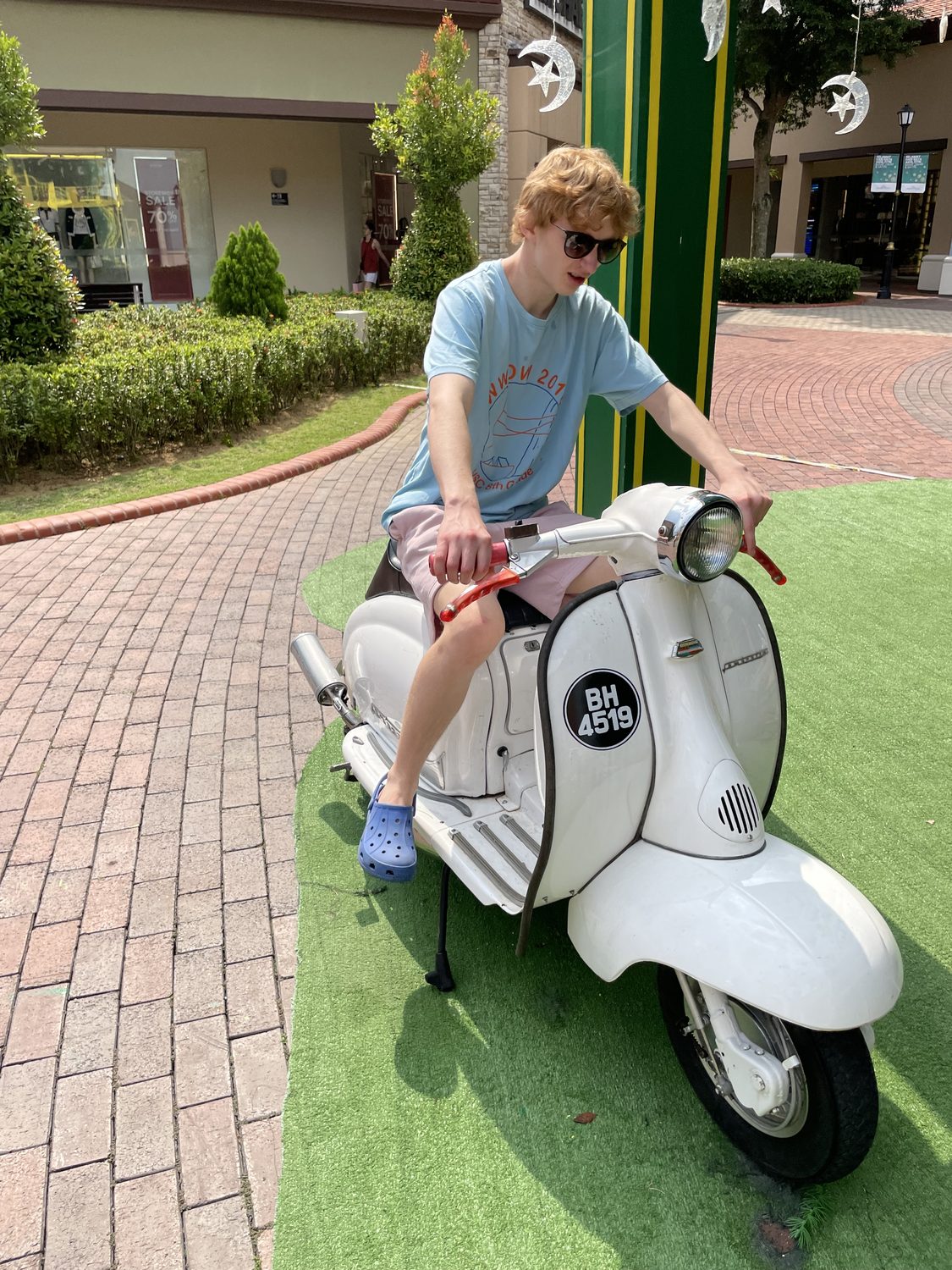 Felix Tinnerholm sitting on a white vintage scooter in Johor Bahru, Malaysia